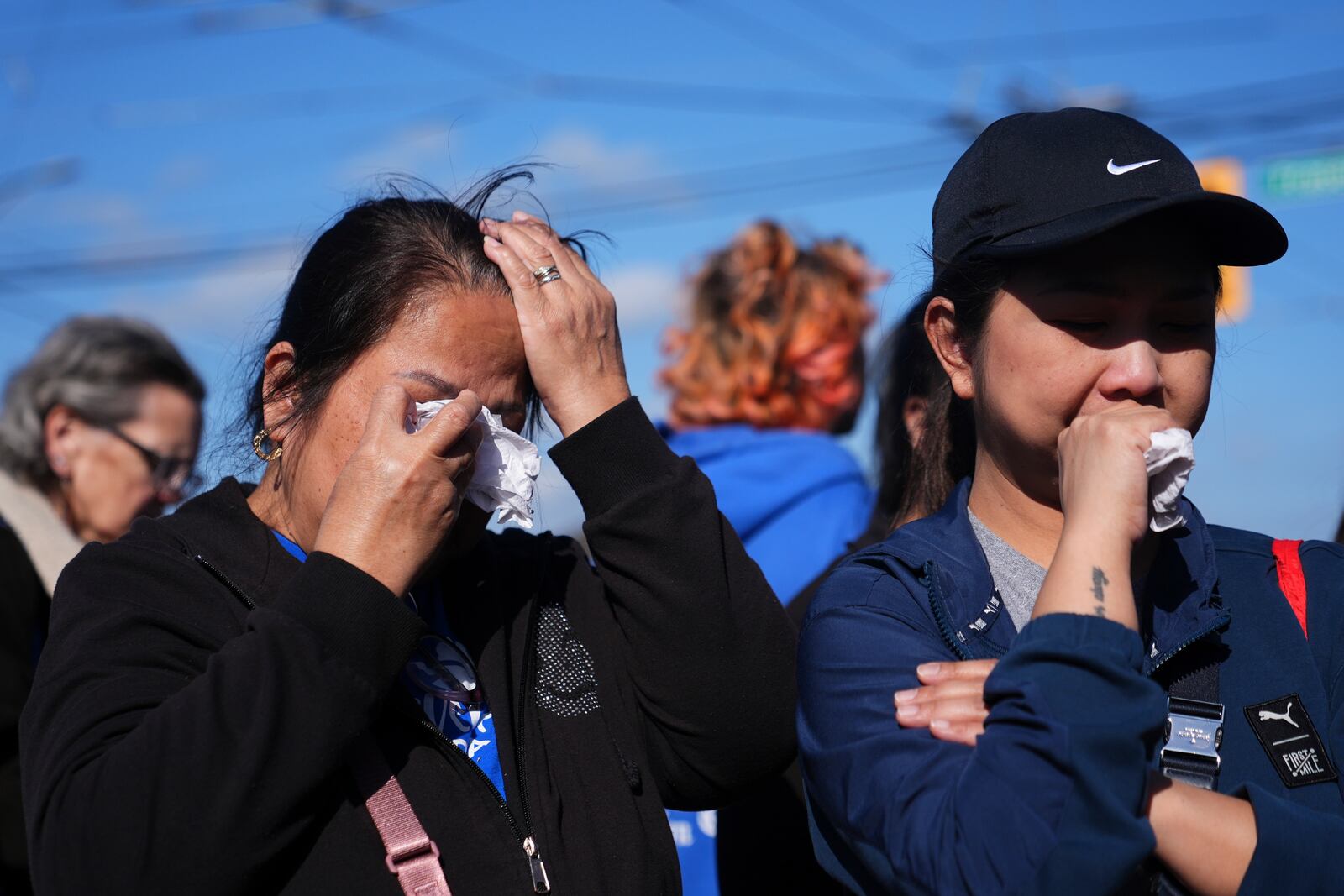 Two people react at a memorial after a vehicle drove into a crowd during a Filipino heritage festival in Vancouver, British Columbia, Sunday, April 27, 2025. (AP Photo/Lindsey Wasson)