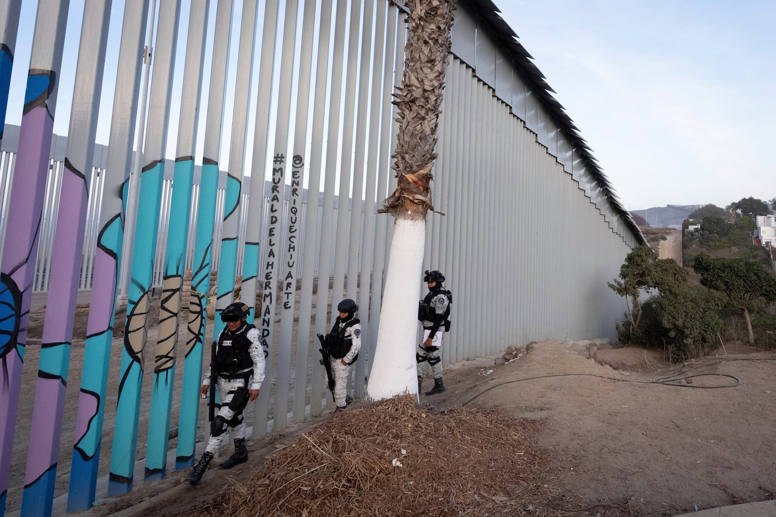 FILE - Members of the Mexican National Guard patrol along the border wall separating Mexico and the United States, in Tijuana, Jan. 20, 2025. (AP Photo/Gregory Bull, File)