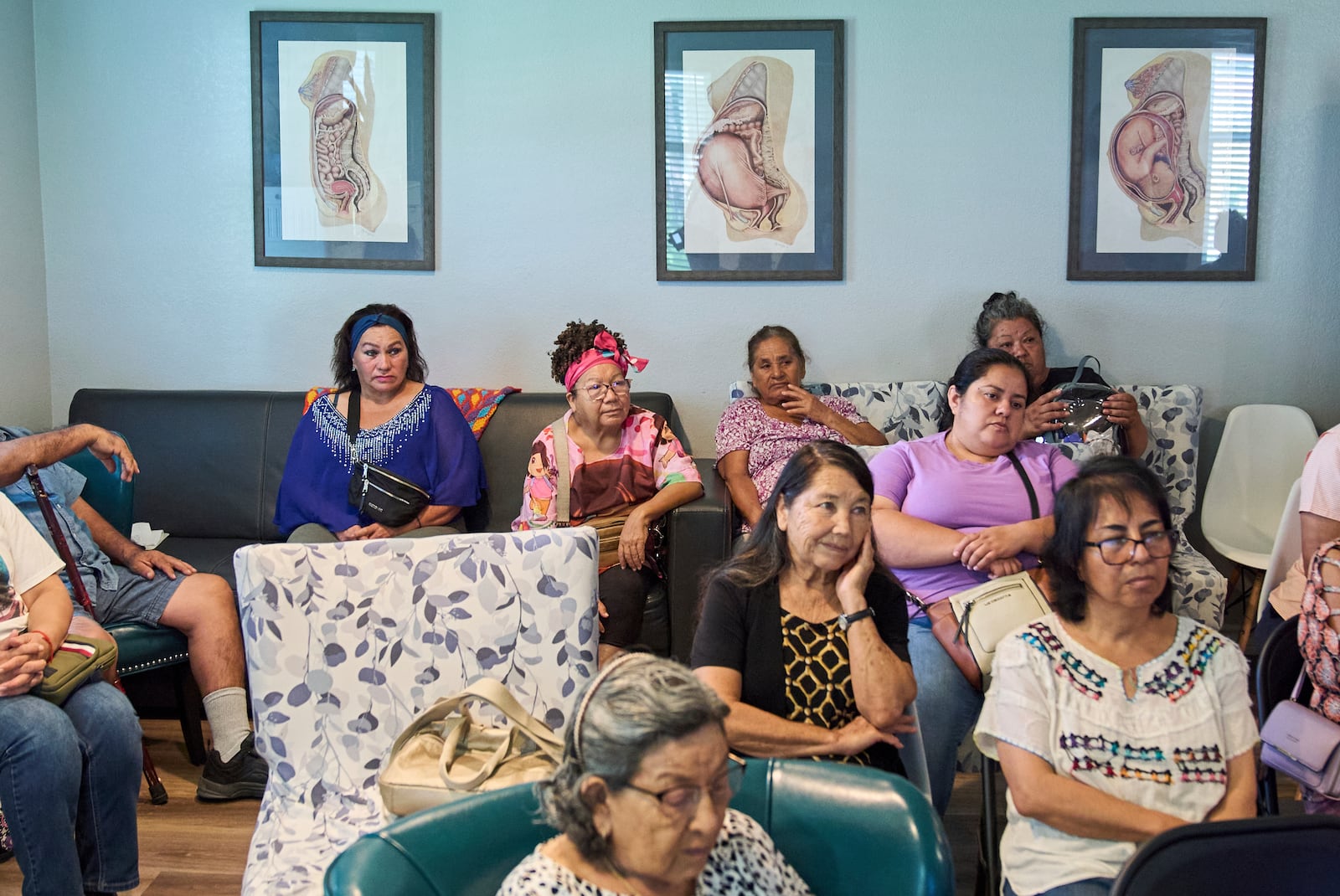 With posters illustrating stages of pregnancy behind them, people attend a health clinic about diabetes held by Holy Family Services, a birth center and women's clinic in the Rio Grande Valley, Wednesday, June 18, 2025, in Weslaco, Texas. (AP Photo/Jacquelyn Martin)