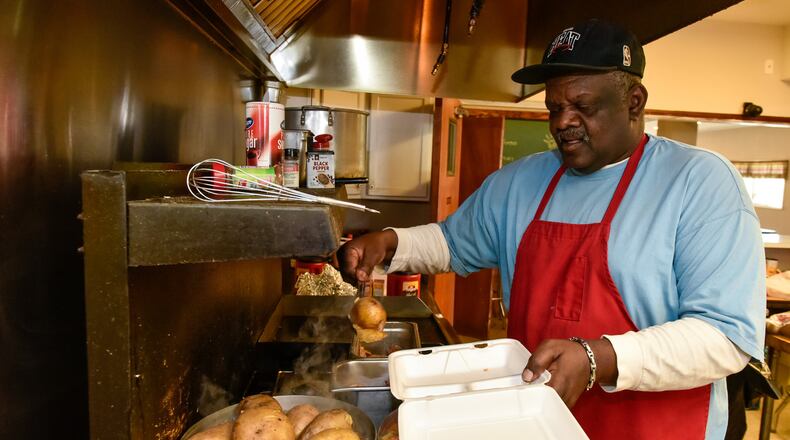 Ollie Lige dishes out a meal Monday, April 20, 2020 at Louella Thomson Cream Center Feed the Hungry Project on Yankee Road in Middletown.
