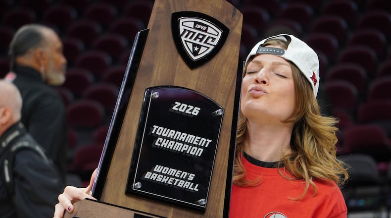 Miami assistant coach Maya Chandler poses for photos while holding the Mid-American Conference Tournament trophy on Saturday, March 14, 2026, at Rocket Arena in Cleveland. CHRIS VOGT / CONTRIBUTED