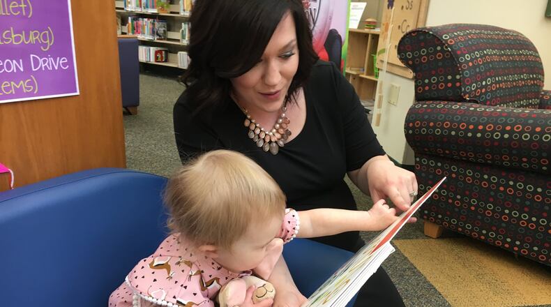 Kari Egbers, of Monroe, says reading to her daughter, Eliot Rose, 2, is part of their daily routine. She participates in the Dolly Parton Imagination Library. RICK McCRABB/STAFF