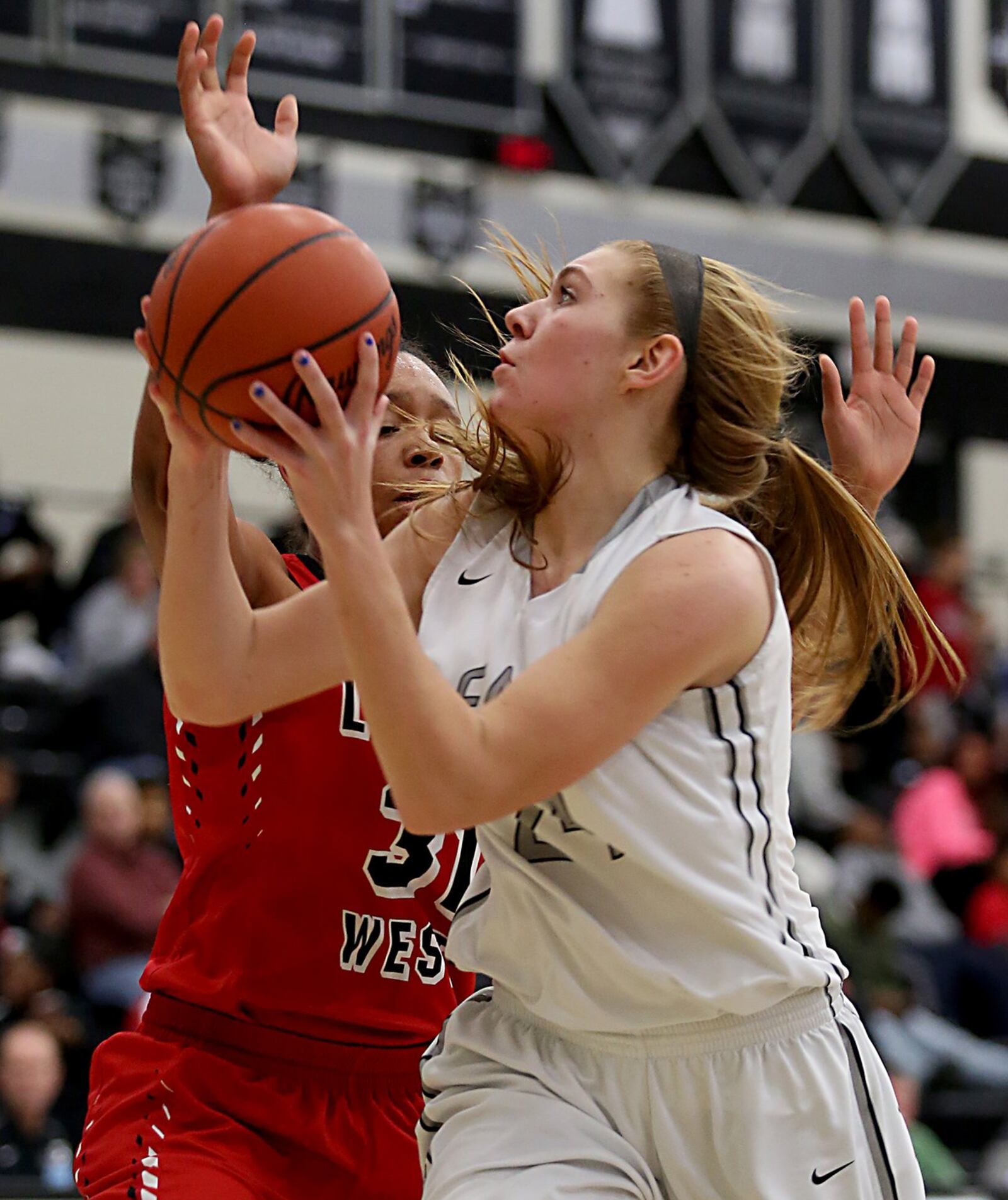 Lakota East forward Bryn Mangold shoots while being covered by Lakota West forward Nevaeh Dean during their game in Liberty Township on Wednesday night. CONTRIBUTED PHOTO BY E.L. HUBBARD