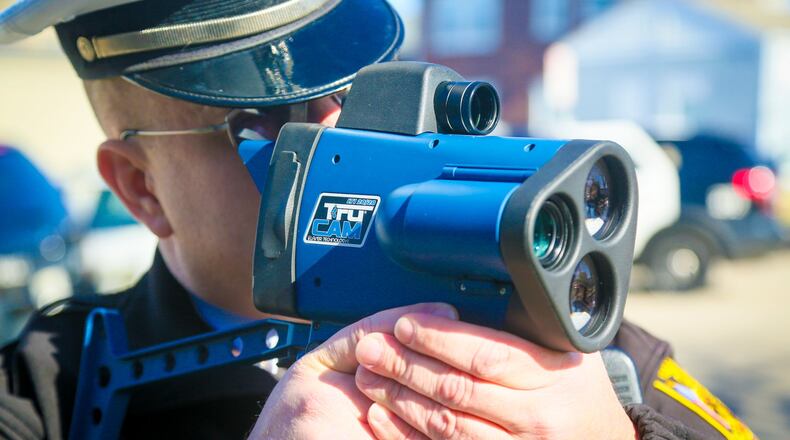 Hamilton police department traffic officer Michael Coleman demonstrates one of their new Laser Technologies LTI20/20 Trucam hand held laser speed measuring devices, Monday, Feb. 13, 2017. The new devices can record video and still photographs. GREG LYNCH / STAFF
