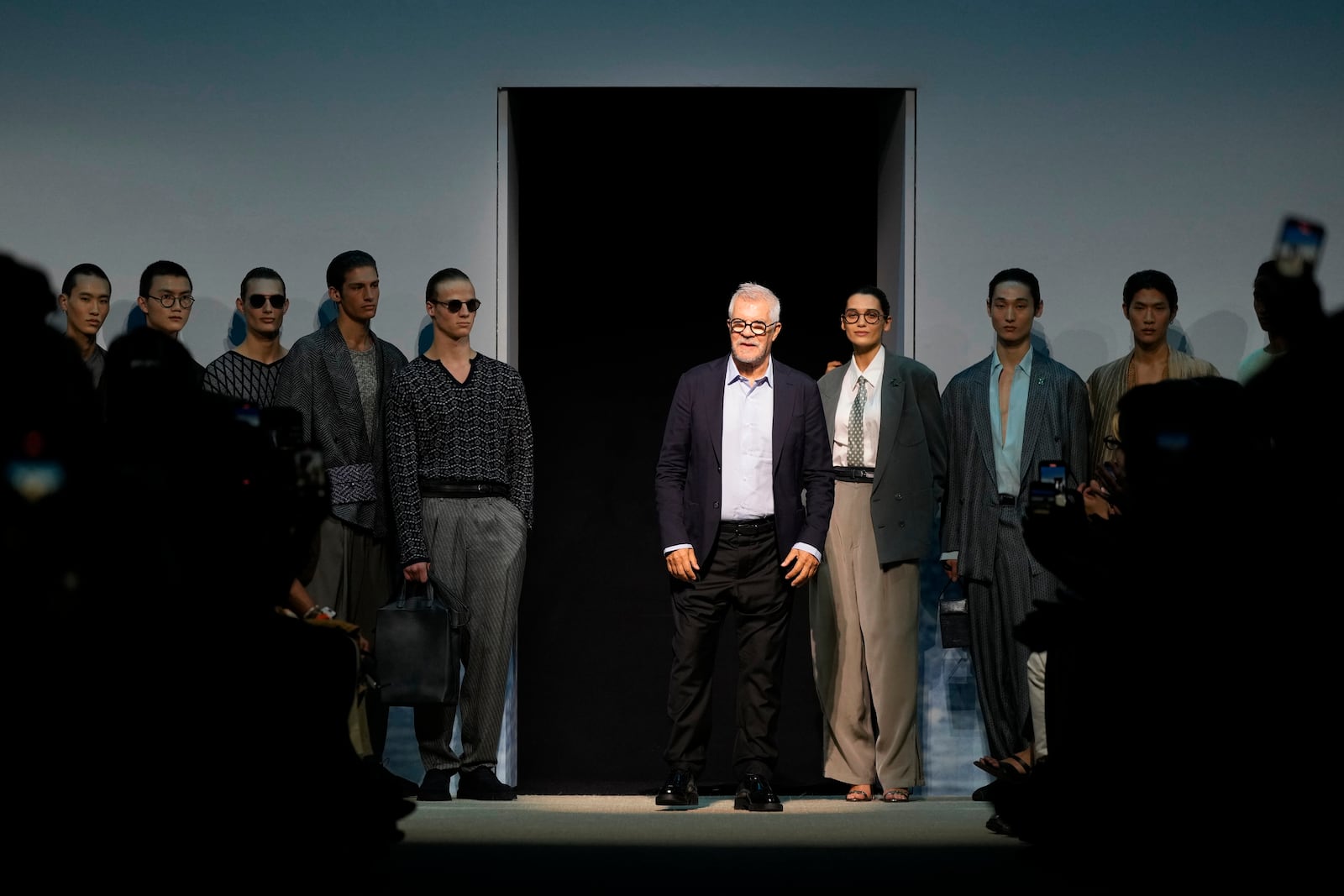 Leo Dell'Orco, centre, accepts applause after the men's Giorgio Armani Spring-Summer 2026 collection, that was presented in Milan, Italy, Monday, June 23, 2025. (AP Photo/Luca Bruno)