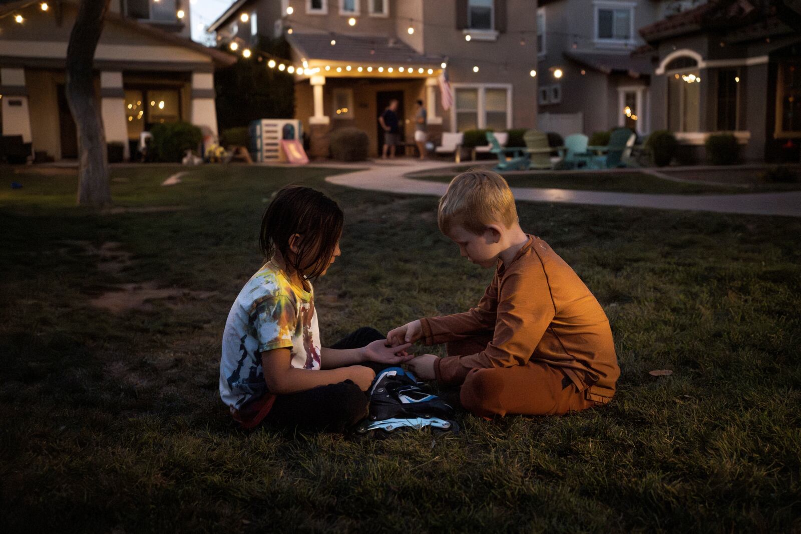 Maverick, left, and Brennan, right, play in Agritopia's "kid pod," a cluster of families with more than 20 kids between them at Agritopia, a community nestled around a plot of agricultural land, on April 21, 2025, in Gilbert, Ariz. (AP Photo/Annika Hammerschlag)