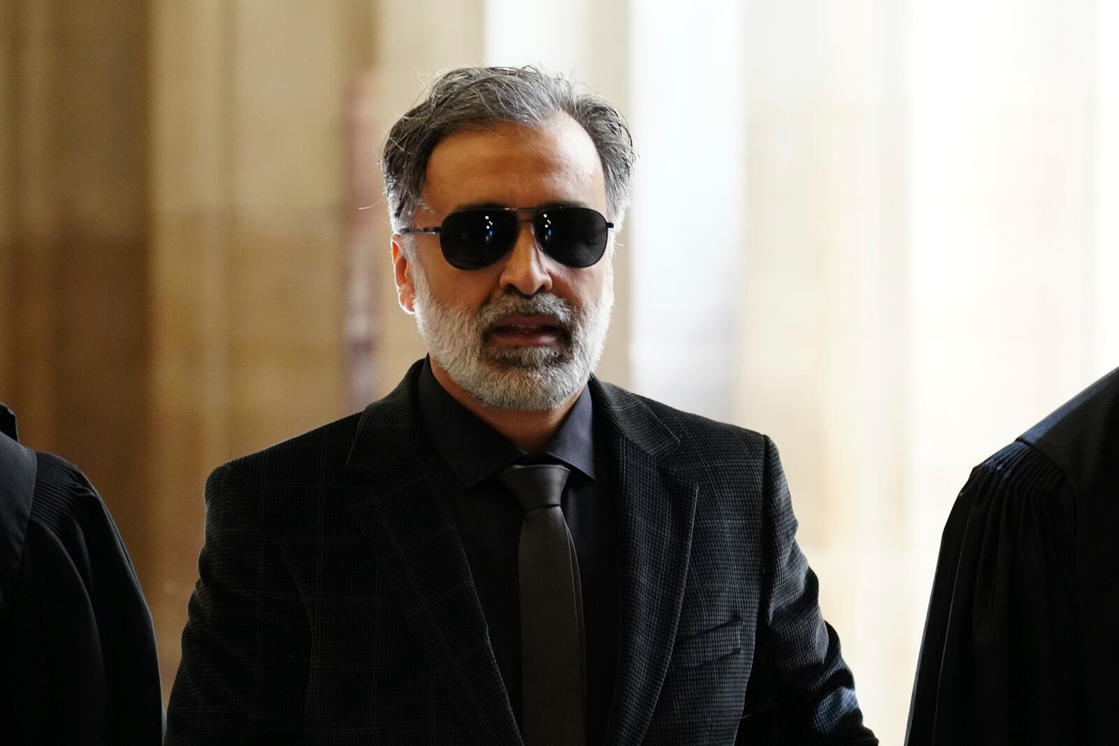 Abderrahmane Ouatiki, who was working as a hotel receptionist and was allegedly held at gunpoint by the robbers during the 2016 armed robbery of Kim Kardashian, arrives at the palace of justice Monday, April 28, 2025 in Paris. (AP Photo/Aurelien Morissard)