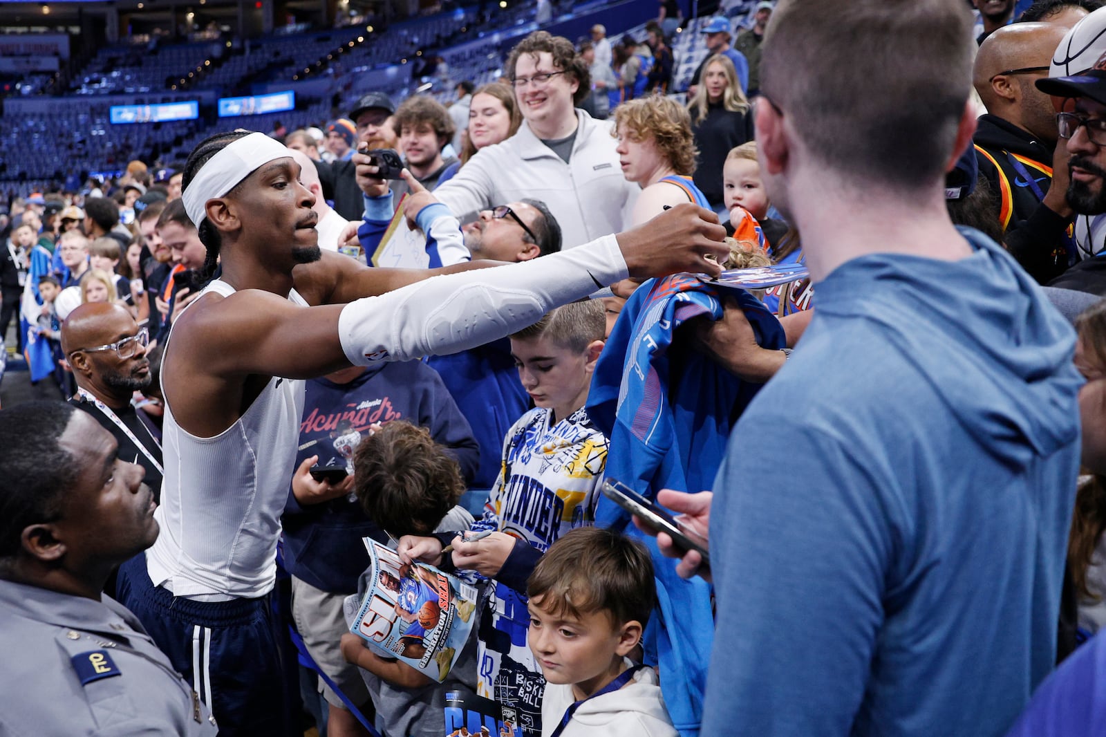 Oklahoma City Thunder guard Shai Gilgeous-Alexander, left, signs autographs for fans before Game 1 of an NBA first-round playoff series against the Memphis Grizzles, Sunday, April 20, 2025, in Oklahoma City. (AP Photo/Nate Billings)