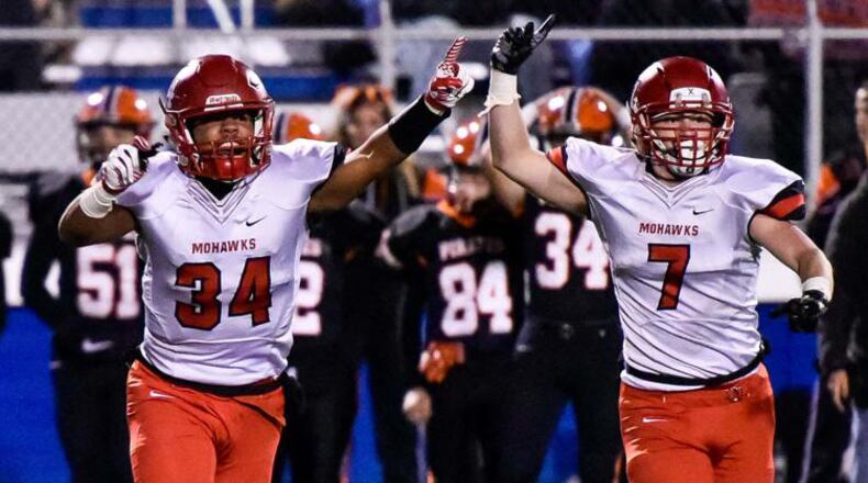 Madison’s Evan Crim (34) and Mason Whiteman (7) celebrate a good moment in a Division V state semifinal on Nov. 24, 2017, at Herrnstein Field in Chillicothe. NICK GRAHAM/STAFF