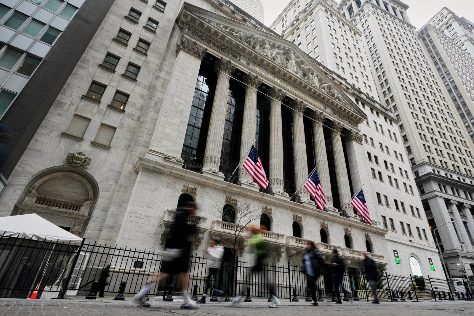 People walk by the New York Stock Exchange, Thursday morning, April 10, 2025. (AP Photo/Richard Drew)
