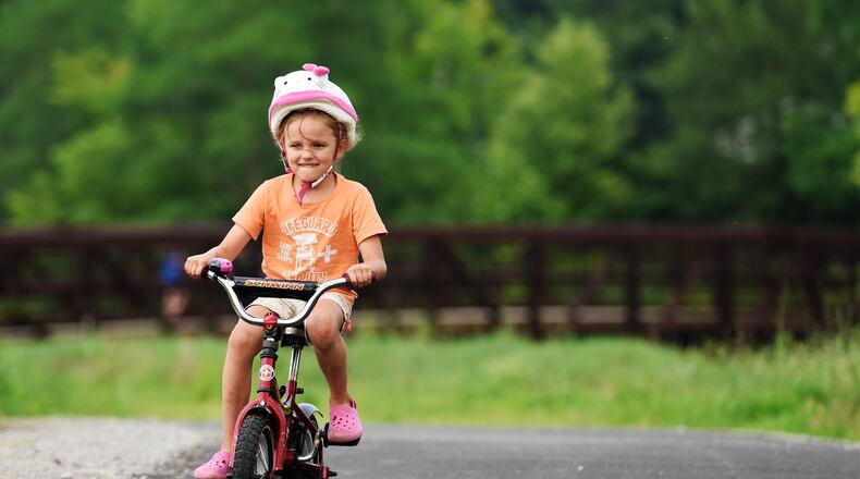 Madelyn Hartkemeyer, 5, rides her bike on the Great Miami River Recreation Trail after a dedication hosted by the Hamilton Community Foundation Wednesday, July 1, 2015, in Fairfield Twp. Monroe is grants to be used in construction of its portion of the trail. NICK GRAHAM/STAFF