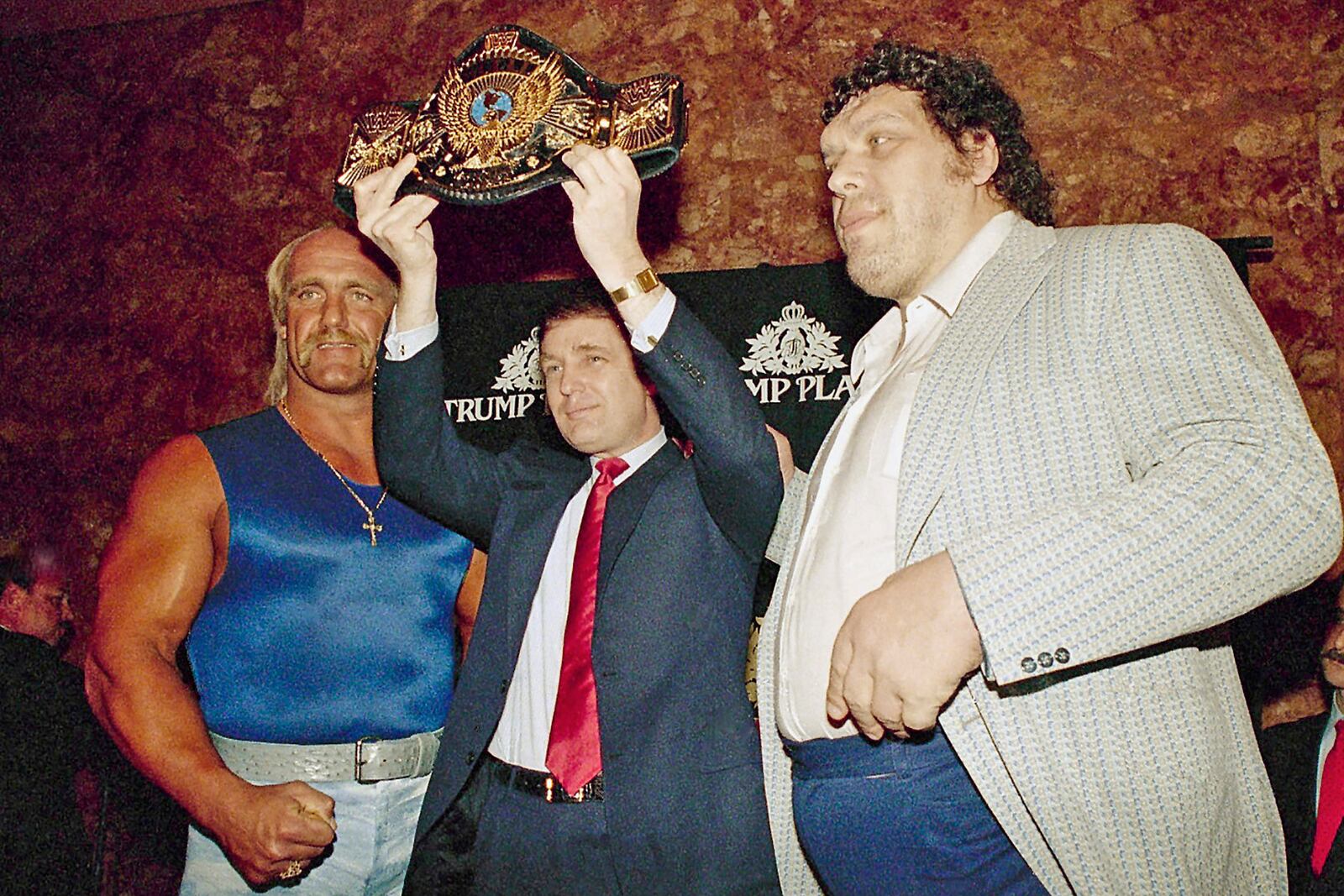 FILE - Real estate developer Donald Trump holds up the World Wrestling Federation Championship belt as he flanked by wrestlers Hulk Hogan, left and Andre the Giant durinig a news conference, Tuesday, March 15, 1988, in New York, announcing "WrestleMania IV" at Trump Plaza in Atlantic City. (AP Photo/Susan Ragan, File)