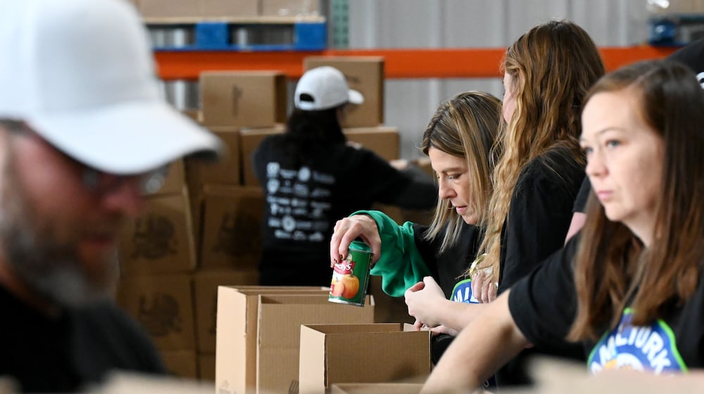 Shared Harvest saw about 60 volunteers from multiple organizations pack boxes on Friday, Nov. 14, 2025, for the annual Hamil-Turkey event where around thousands of people will be fed through these prepackaged Thanksgiving dinners. Hundreds of more people are expected to be fed at a Thanksgiving buffet dinner sponsored by various organizations. MICHAEL D. PITMAN/STAFF
