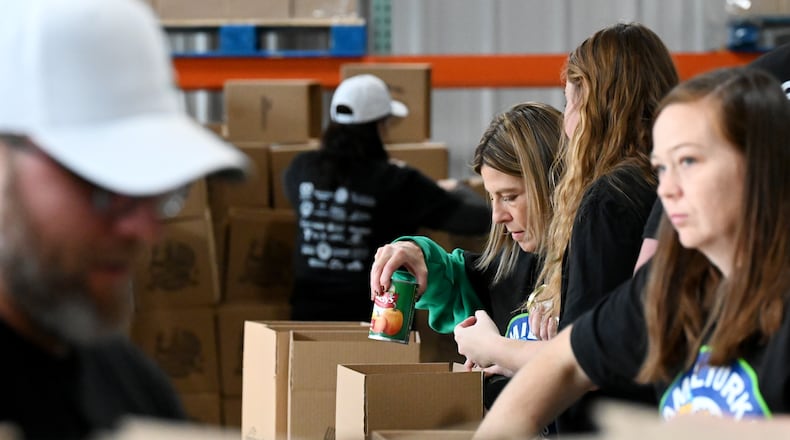 Shared Harvest saw about 60 volunteers from multiple organizations pack boxes on Friday, Nov. 14, 2025, for the annual Hamil-Turkey event where around thousands of people will be fed through these prepackaged Thanksgiving dinners. Hundreds of more people are expected to be fed at a Thanksgiving buffet dinner sponsored by various organizations. MICHAEL D. PITMAN/STAFF