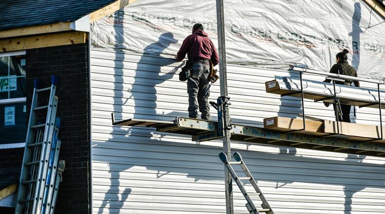 Crews install siding on a house being built by Cristo Homes on Governors Avenue Thursday, Feb. 21 in Trenton. NICK GRAHAM/STAFF