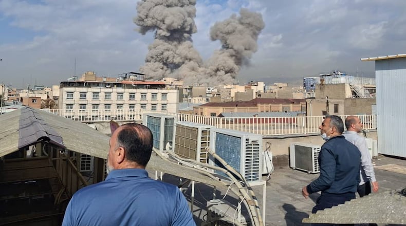 People watch as smoke rises on the skyline after an explosion in Tehran, Iran, Saturday, Feb. 28, 2026.(AP Photo)