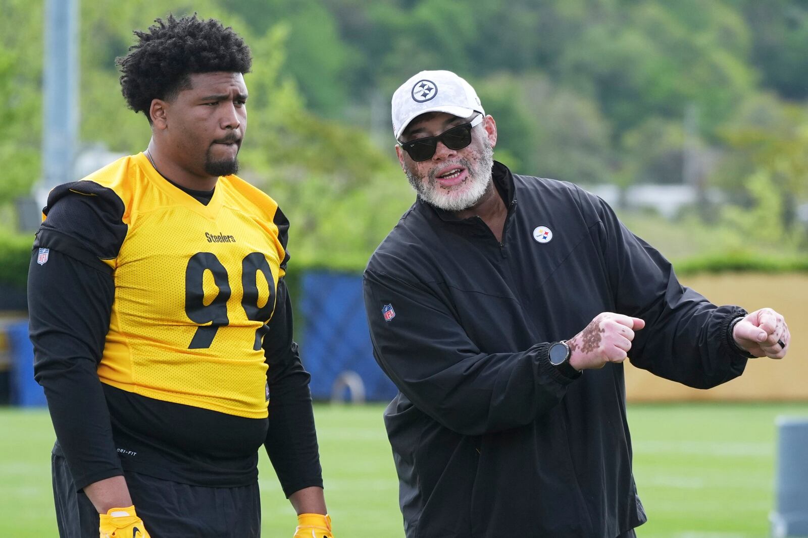 Pittsburgh Steelers first round draft pick Derrick Harmon (99) listens as defensive line coach Karl Dunbar explains a drill during the during the NFL football team's rookie camp in Pittsburgh, Friday, May 9, 2025. (AP Photo/Gene J. Puskar)