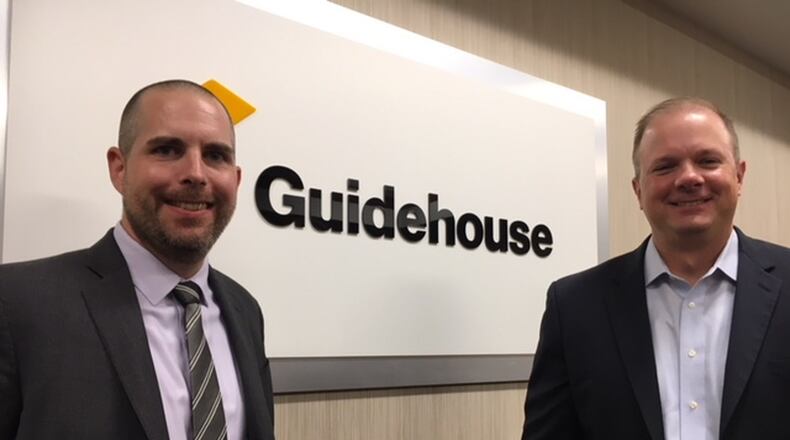 Justin Lambert (left), a management consultant at Guidehouse’s Beavercreek office, and Jim Ebel, the partner at the office. THOMAS GNAU/STAFF