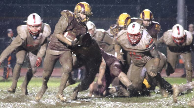Dylan Caldwell of Ross takes a run through the mud Friday night during a game against visiting Talawanda at Robinson Field in Ross Township. The host Rams won 18-7. CONTRIBUTED PHOTO BY KAREN REDEMEIER