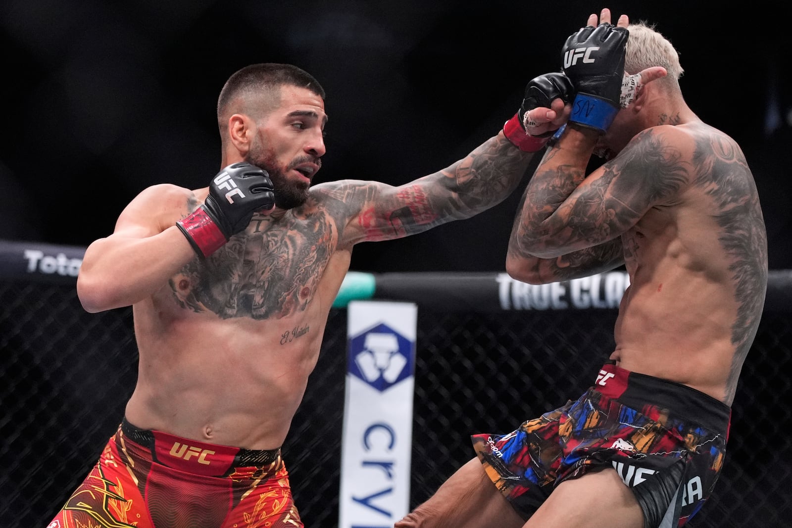 Ilia Topuria, left, fights Charles Oliveira in a lightweight title fight at UFC 317, Saturday, June 28, 2025, in Las Vegas. (AP Photo/John Locher)