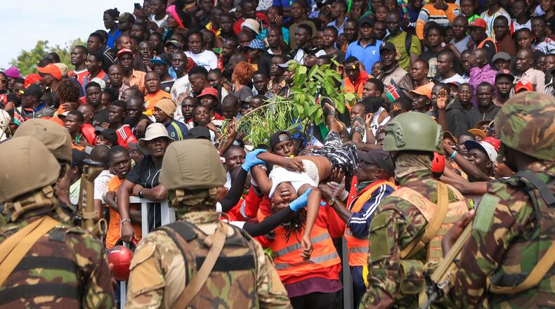 A woman is evacuated after fainting during the viewing of the body of former Kenya Prime Minister Raila Odinga at Jomo Kenyatta Stadium in Kisumu, Kenya, Saturday, Oct. 18, 2025. (AP Photo/Andrew Kasuku)