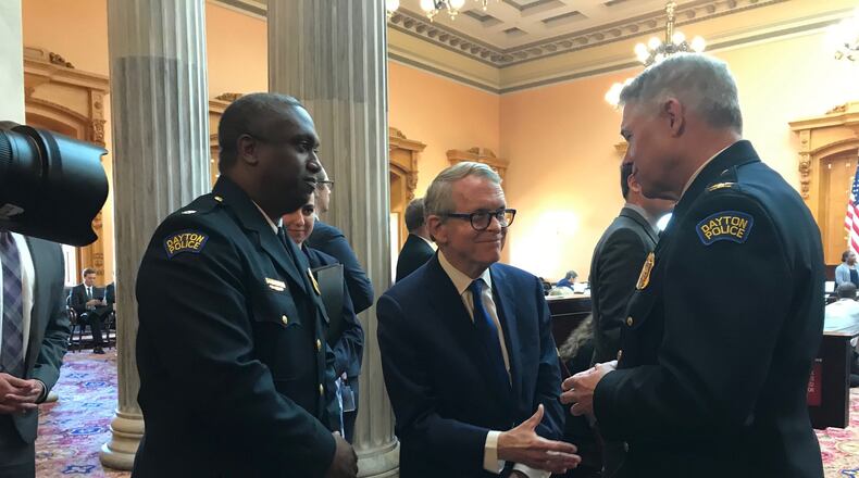 Governor DeWine talks with Dayton Police Chief Biehl and Assistant Police Chief Henderson before they received accommodation during the Ohio Senate meeting on Wednesday. STAFF PHOTO / SARAH FRANKS