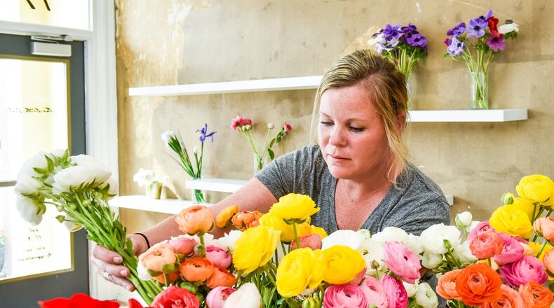 Mindy Staton prepares arrangements at Two Little Buds in Hamilton. The business recently moved from Bridgewater Falls to Hamilton and offers wedding and event arrangements. It specializes in locally grown flowers. NICK GRAHAM/STAFF