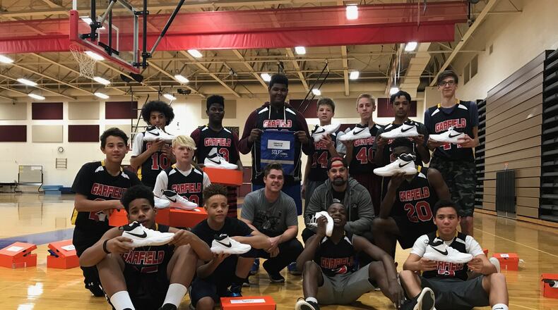 The Hamilton Christian Center piloted an initiative called Soles for Souls, which provided athletic shoes for the Garfield Middle School eighth grade boys basketball team as well as game day nutrition for the boys and girls seventh and eighth grade basketball teams. Pictured is the eighth grade team showing off their new basketball shoes. CONTRIBUTED