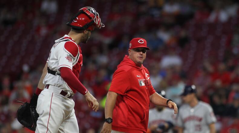Reds pitch coach Derek Johnson, right, talks to catch Curt Casali after a mound visit during a game against the Astros on Monday, June 17, 2019, at Great American Ball Park in Cincinnati. David Jablonski/Staff