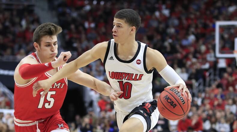 LOUISVILLE, KENTUCKY - DECEMBER 18: Samuell Williamson #10 of the Louisville Cardinals dribbles the ball against Miami’s Milos Jovic at KFC YUM! Center on December 18, 2019 in Louisville, Kentucky. (Photo by Andy Lyons/Getty Images)