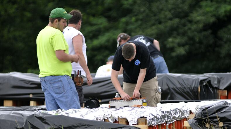 In this 2015 file photo, Rozzi’s Famous Fireworks employees make final adjustments to the explosives for Red, White & Kaboom at Harbin Park in Fairfield. MICHAEL D. PITMAN/STAFF