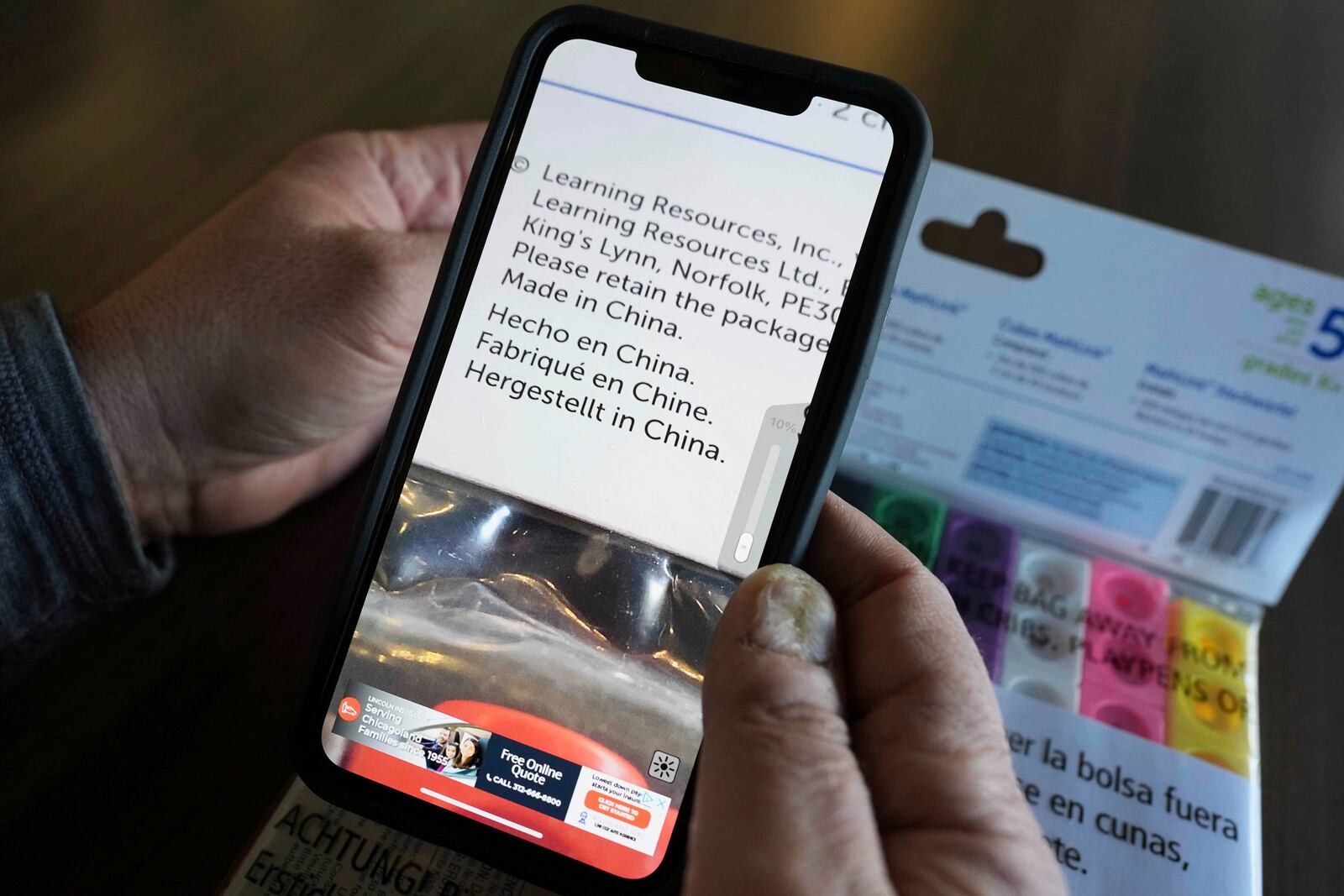 Rick Woldenberg, CEO of Learning Resources, an educational toy company, uses his mobile magnifier app to check the product which are manufactured in China, at a showroom in Vernon Hills, Ill., Friday, April 11, 2025. (AP Photo/Nam Y. Huh)