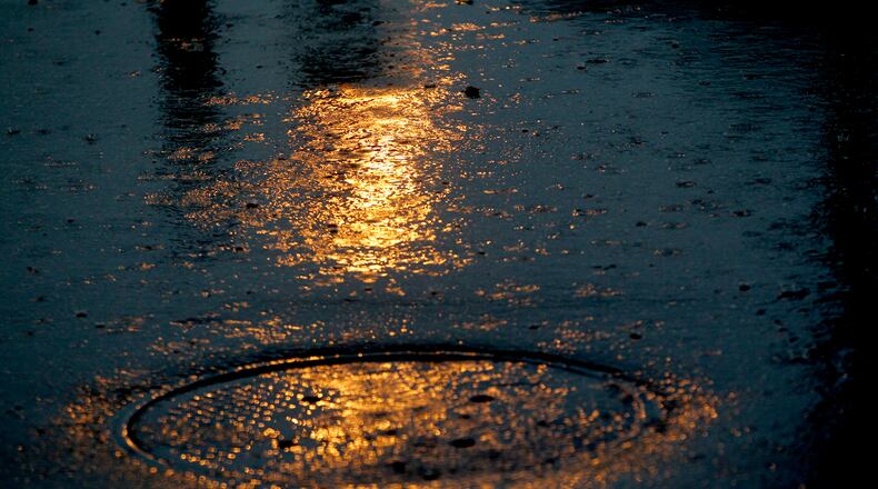Rain falls across a parking lot in Dayton.  LISA POWELL / STAFF