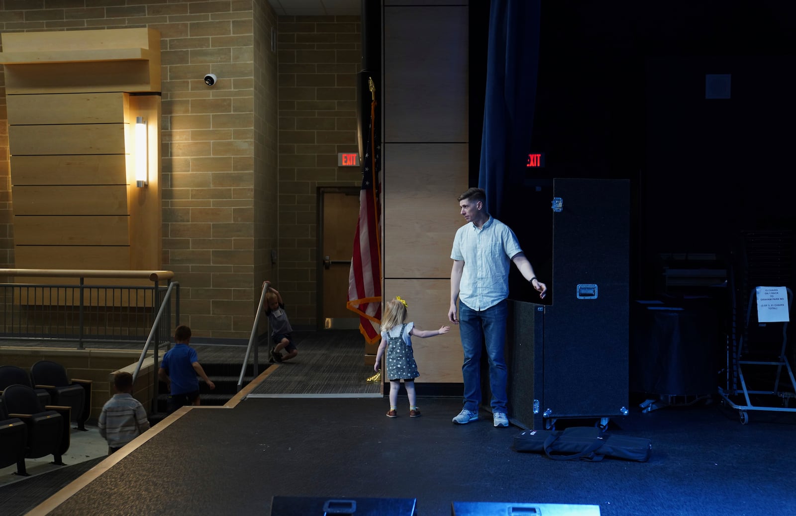 Jake Rogers, a pastor and former member of the U.S. Marine Corps, and his daughter help clean up the stage after church on Sunday, April 6, 2025, at Pillar Church in Dumfries, Va. (AP Photo/Jessie Wardarski)