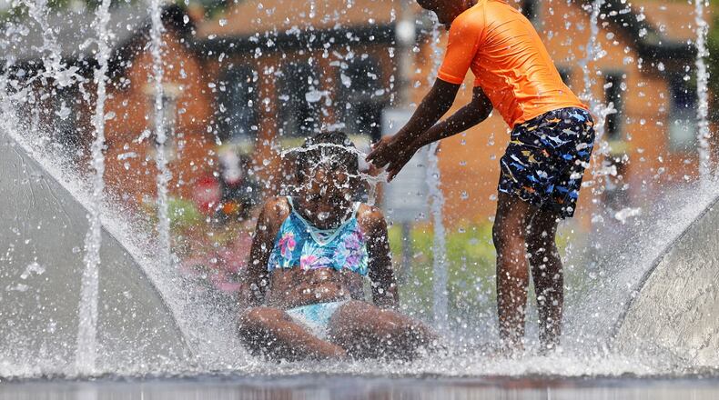 Dadiso Mupeyiwa, 9, left, and Mukundi Mupeyiwa, 6, play in the water at Marcum Park Wednesday, July 20, 2022, in Hamilton. NICK GRAHAM/STAFF
