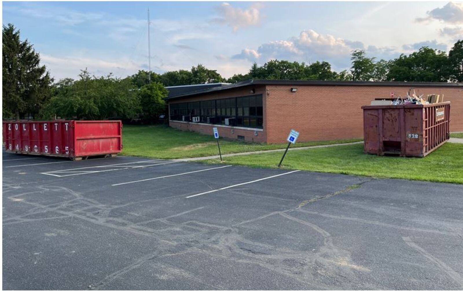 Large Dumpsters have been placed around the Hampton Bennett School Building as crews clear out the building as well as perform asbestos abatement prior to the building's demolition. The 68-year-old building served as a middle and junior high school in the 1950s and 1960s. It also served as the Franklin City Schools central administrative offices, special and gifted education, a Kindergarten and Pre-K Early Childhood Center. The building will be razed for a  parking lot for the new Franklin High School next door. ED RICHTER/STAFF