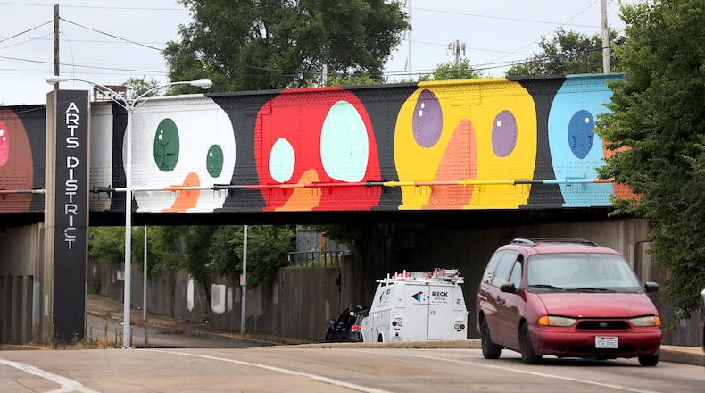 A whimsical mural of birds decorates the train overpass near the intersection of Keowee and First streets. LISA POWELL / STAFF