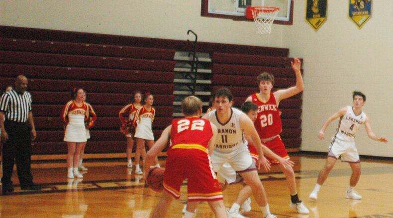 Fenwick’s C.J. Napier (22) looks inside toward teammate A.J. Braun (20) as Lebanon’s Zach Huffman (11) defends Saturday night at Lebanon. Napier’s two free throws with 3.7 seconds left gave the Falcons a 44-43 victory. RICK CASSANO/STAFF
