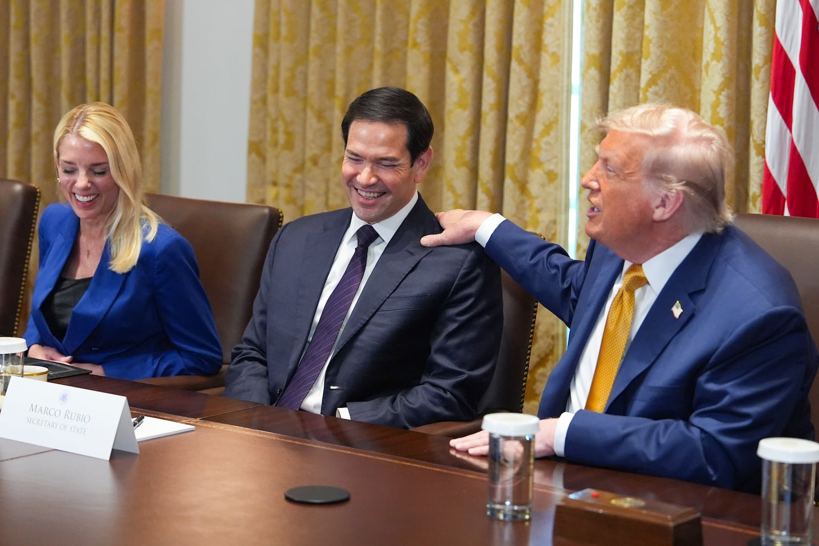 President Donald Trump, right, puts his hand on shoulder of Secretary of State Marco Rubio, center, as Attorney General Pam Bondi, left, looks on during a cabinet meeting at the White House, Tuesday, July 8, 2025, in Washington. (AP Photo/Evan Vucci)