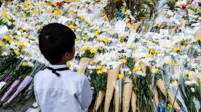 People offer flowers for the victims near the site of a deadly fire at Wang Fuk Court, a residential estate in the Tai Po district of Hong Kong's New Territories on Tuesday, Dec 2, 2025. (AP Photo/Chan Long Hei)