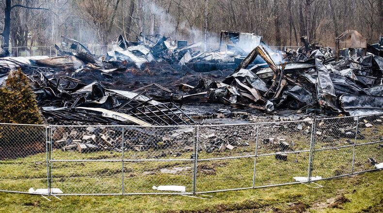 Smoke continues to billow out of sections of Wholesale Tire Mart Tuesday, Feb. 25 a week after a massive fire destroyed the business on Alert New London Road in Morgan Township. NICK GRAHAM / STAFF