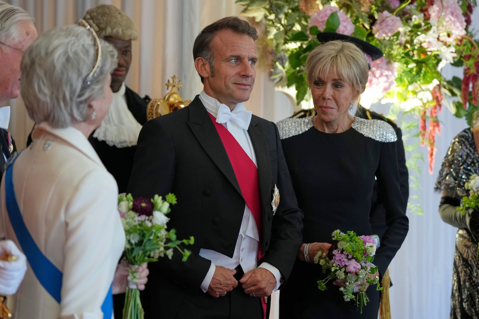 French President Emmanuel Macron, center, and his wife Brigitte, arrive at the Guildhall banquet in London, Wednesday, July 9, 2025. (AP Photo/Alastair Grant)