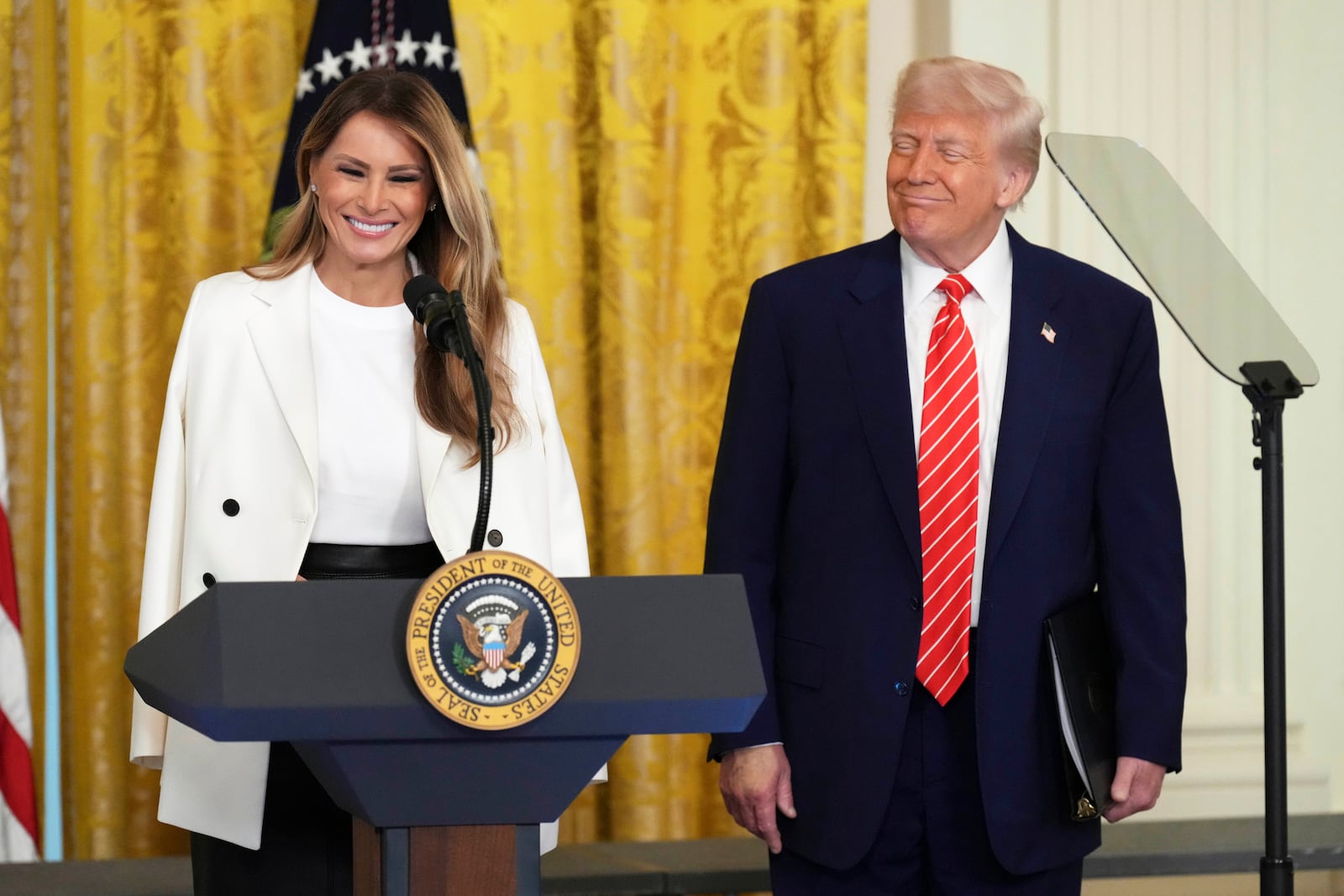 President Donald Trump, right, watches as first lady Melania Trump speaks at an event for Military Mothers, Thursday, May 8, 2025, in the East Room of the White House in Washington. (AP Photo/Jacquelyn Martin)
