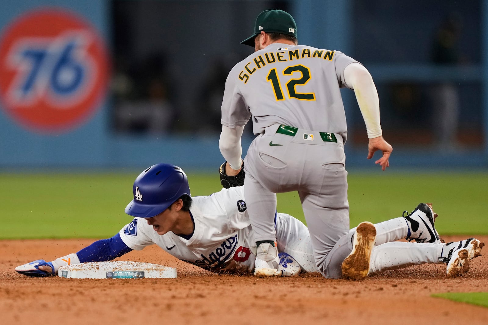 Los Angeles Dodgers' Hyeseong Kim, left, steals second next to Athletics second baseman Max Schuemann during the second inning of a baseball game Thursday, May 15, 2025, in Los Angeles. (AP Photo/Mark J. Terrill)