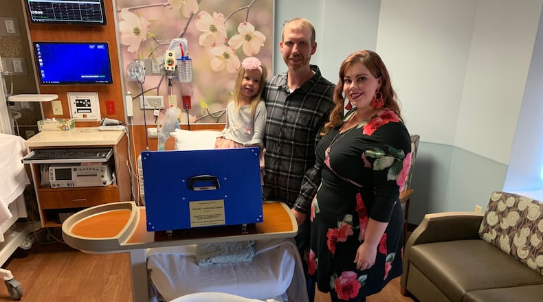 Mercy Health-Fairfield Hospital dedicated its first cuddle cot Tuesday, Nov. 5, 2019, in memory of Timothy Anderson Smith, Ashley and Joseph Smith’s son, a 2014 stillbirth. The new device includes a water-based cooling system designed to keep the body temperature of a deceased infant low, allowing grieving parents and their family as much time as they need to be with the child. Pictured with the Smiths is their 3-year-old daughter, Sonia Grace. CONTRIBUTED