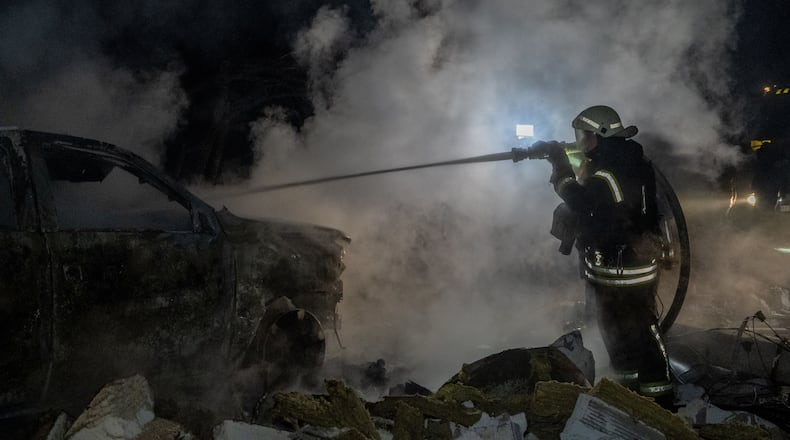 Rescue workers put out a fire of a residential building damaged by a Russian strike in Kharkiv, Ukraine, late Sunday, Nov. 23, 2025. (AP Photo/Andrii Marienko)