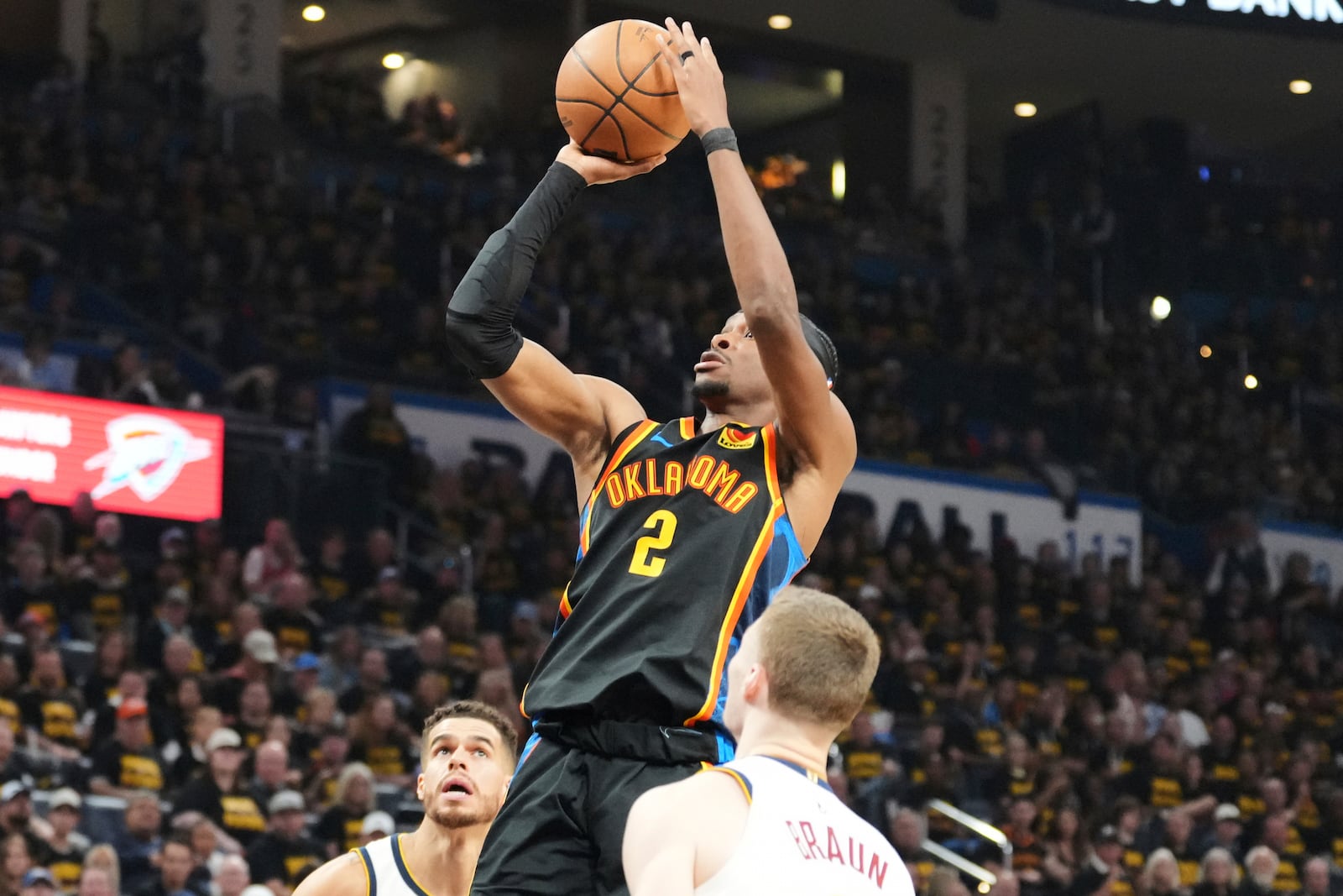 Oklahoma City Thunder's Shai Gilgeous-Alexander (2) shoots as Denver Nuggets' Christian Braun, front, and Michael Porter Jr., rear, defend in the second half of Game 2 in the conference semifinals of the NBA basketball playoffs, Wednesday, May 7, 2025, in Oklahoma City. (AP Photo/Kyle Phillips)