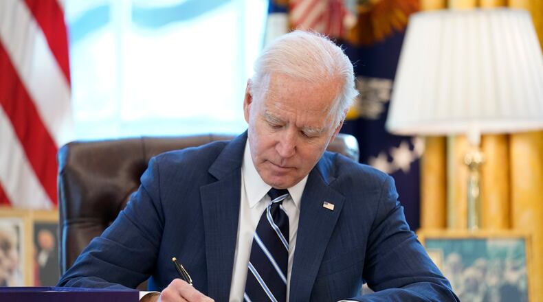 President Joe Biden signs the American Rescue Plan, a coronavirus relief package, in the Oval Office of the White House, Thursday, March 11, 2021, in Washington. (AP Photo/Andrew Harnik)
