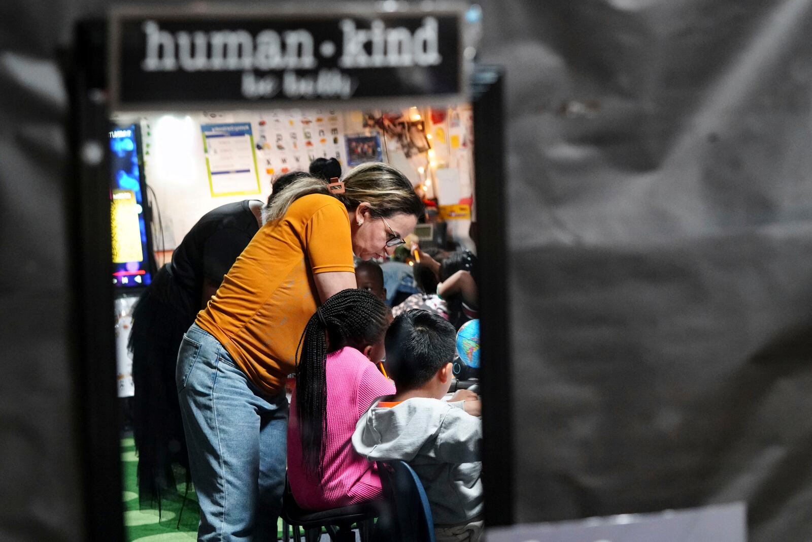 Classroom aid Zhour Boutyebi works with students in a second grade math class at Place Bridge Academy, May 20, 2025, in Denver. (AP Photo/Rebecca Slezak)