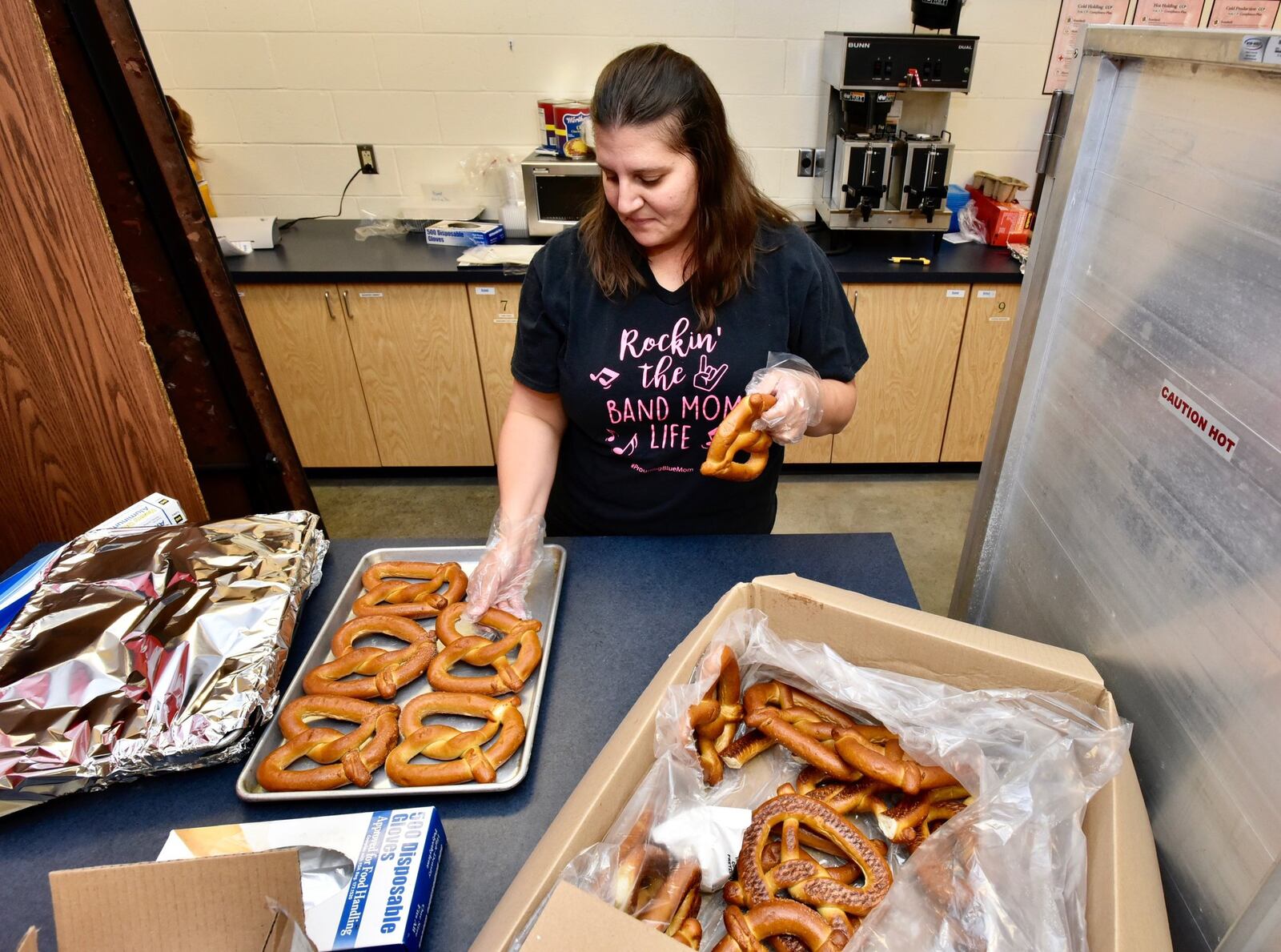 Makayla Baker prepares pretzels Thursday, Aug. 23, ahead of the first game of the season Friday in Hamilton. The concession stand is operated by band parents and volunteers. 
